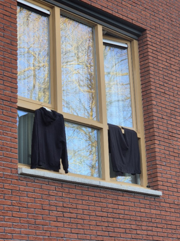 Kleding drogend uit het raam van de hotelkamer.